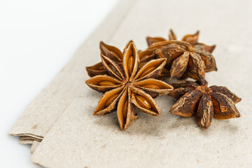 Fototapeta na wymiar star anise on brown paper background front view close up.
