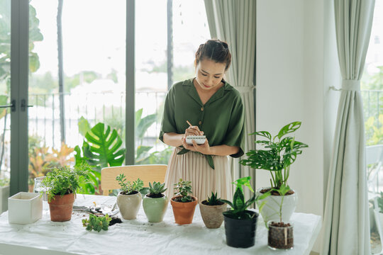 Gardener making notes in a workbook standing at a table