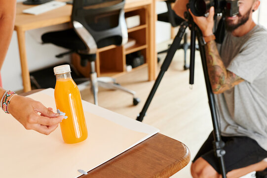 Assistant holding a bottle for a photo shoot