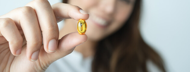 close up woman holding fish oil her hands