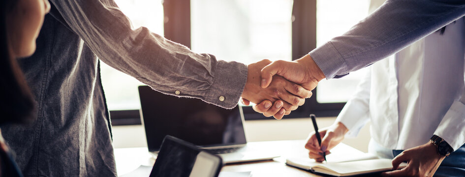 Two businessmen handshaking in meeting after final project agreement deal done.