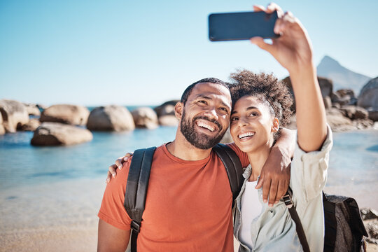 Couple, love and phone selfie on beach for travel adventure or summer vacation. Happy man, woman smile and photography for holiday lifestyle on 5g smartphone for social media at ocean water outdoors