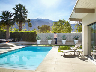 Man watering plants in backyard
