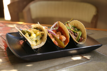 Delicious tacos with shrimps and vegetables on table