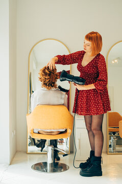 Pregnant Hairdresser Blow-Drying Client's Hair 