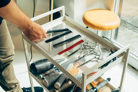 Cropped Image of Hairdresser's Hand Choosing Comb