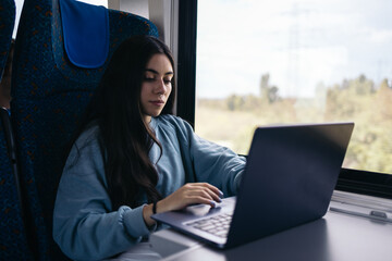 Freelance woman working with laptop from the train