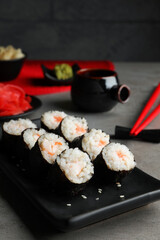Tasty sushi rolls served on grey table