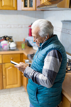 Grandfather talking on phone call with a smartphone and headphones