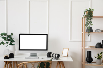 Photographer's workplace with computer and equipment in light office