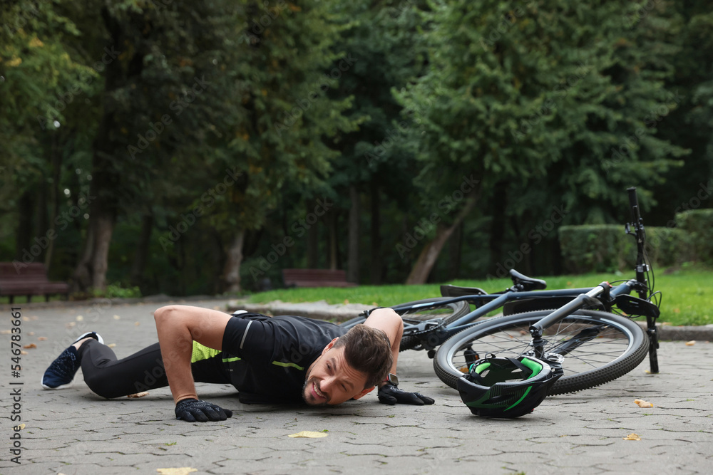 Wall mural Man fallen off his bicycle in park