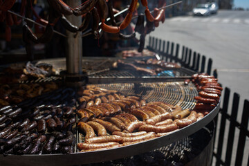A large number of grilled sausages and sausages for sale outside at a food festival or fair.