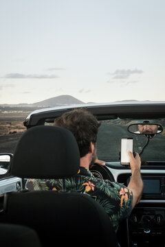 Anonymous man driving and using phone gps