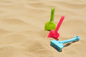 Fototapeta na wymiar Set of colorful beach toys on sand, space for text