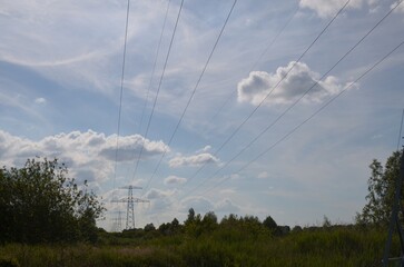 Fototapeta na wymiar Modern high voltage towers in field on sunny day