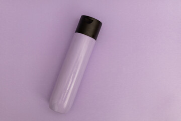 Shampoo for hair in a stylish purple plastic jar on purple background, monochrome items