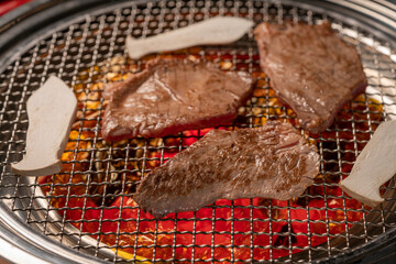 Sliced Wagyu Beef on hot charcoal Asian BBQ food style, Grilled Beef Sirloin meat on the charcoal stove,Korean BBQ style.