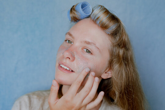 girl applying scrub on her face