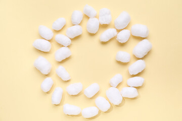 Frame made of soft cotton balls on beige background