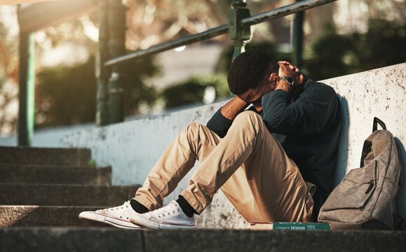 Student, mental health and depression with anxiety, burnout and sad for exam results, fail or mistake while sitting outdoor. Young man, stress and tired and depressed on university or college campus