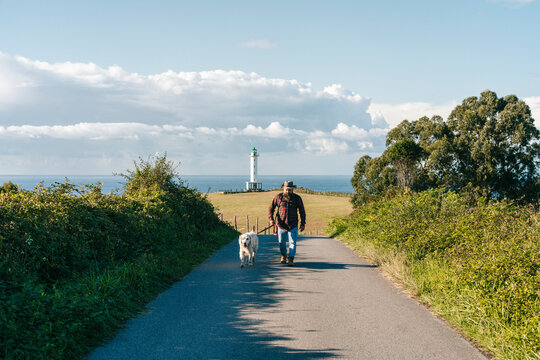 Man and dog walking towards camera in countryside