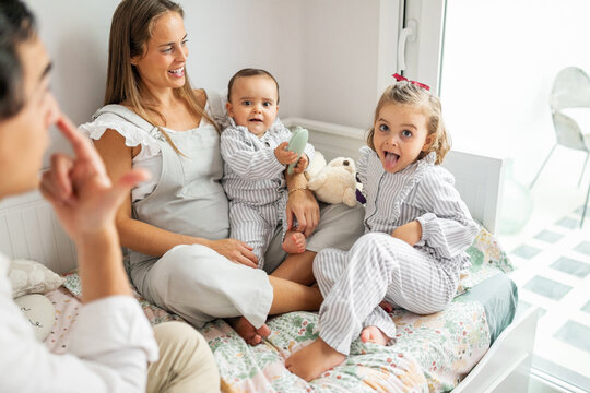 Family Playing All Together In Children's Bedroom