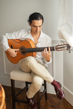 man playing guitar at home