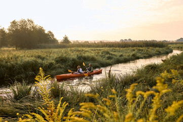 Man and woman row to shore in kayak