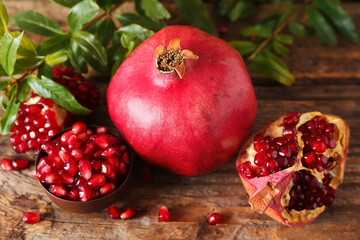 Fresh pomegranates and seeds on wooden background, closeup