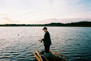 Film photo of a fisherman in a boat at sunset