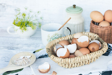 Fototapeta na wymiar Brown and white eggshells placed in basket in home kitchen on table, eggshells stored for making natural fertilizers for growing vegetables, sustainability concept