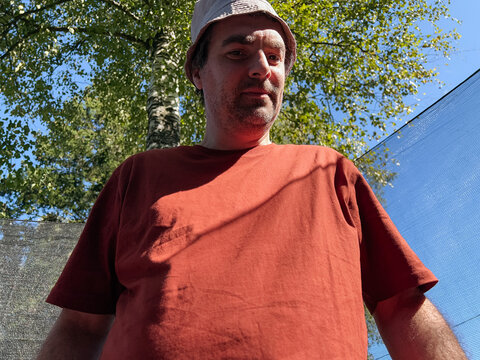 Mature man wearing a sun hat and terracotta t-shirt 