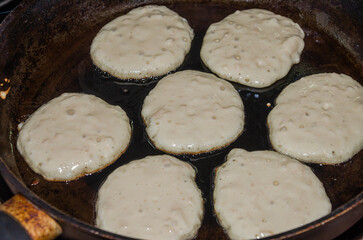The cook is frying pancakes in a frying pan	

