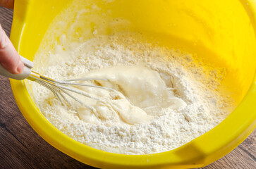 The cook beats the flour with a whisk into the dough for pancakes	
