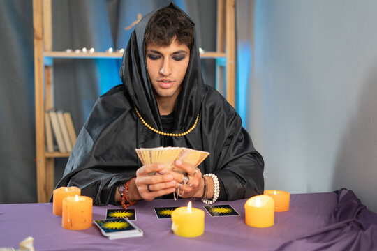 Tarot reader picking tarot cards.Candlelight in dark.Tarot reader or fortune teller reading and forecasting