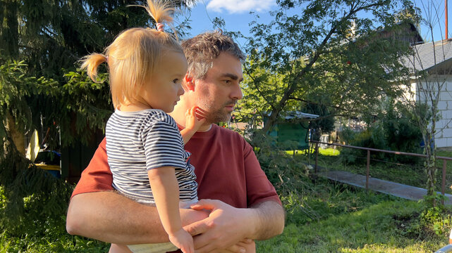 Man standing outside and holding his small daughter