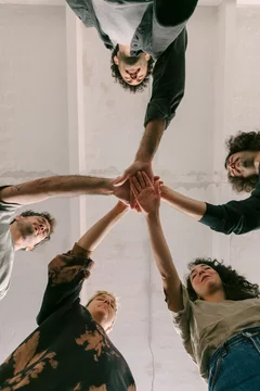Five People Touching Hands in Group Therapy Context