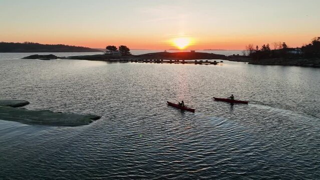 Aerial view around kayakers, paddling in the archipelago, during sunset