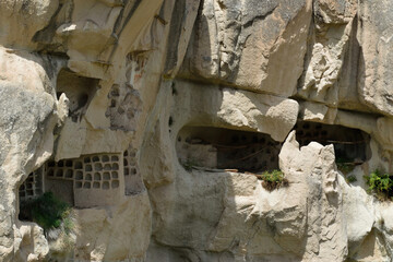 Close-up photo of ancient cave dwellings carved in stone at Goreme National Park, Cappadocia, Turkey