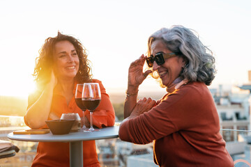 Happy senior women drinking wine on terrace