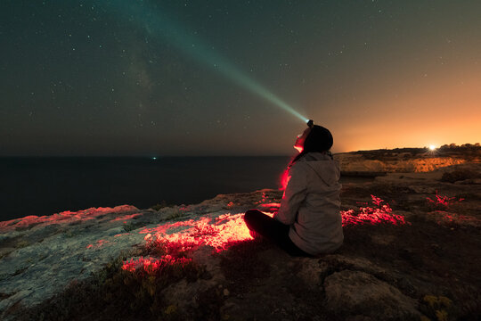Woman looking at the stars with head torch