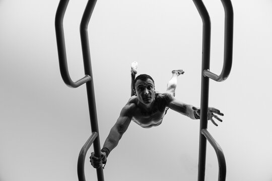 young man hand-walking on the bars - monochrome creative portrait