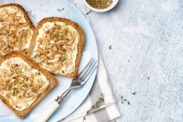 Plate of tasty toasts with cream cheese, mushrooms and spices on light background, closeup