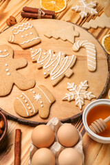 Board with tasty Christmas cookies on wooden background, closeup