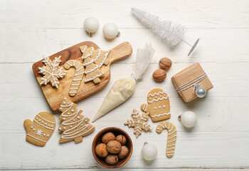 Fototapeta na wymiar Composition with tasty Christmas cookies, gift, decorations and walnuts on light wooden background