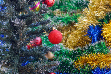Red ball on Christmas tree colorful blurry background