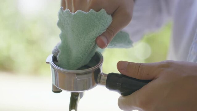 Close Up Slow motion Barista using Fabric Cleaning Potra fillter coffee tools equipment.