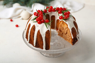 Dessert stand with delicious Christmas cake on light background
