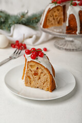Plate with piece of tasty Christmas cake on light background