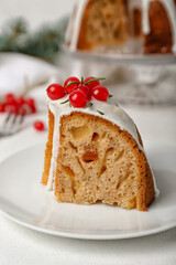 Plate with piece of tasty Christmas cake on light background, closeup